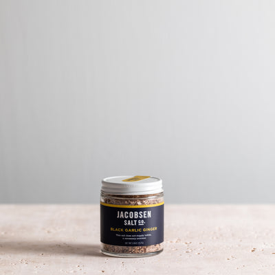 A 2.6 oz jar of Jacobsen Infused Black Garlic Ginger Salt.