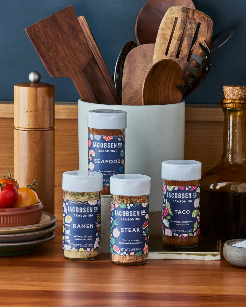 Jacobsen Co. Seasonings on kitchen counter, including Ramen Seasoning, Seafood Seasoning, Steak Seasoning and Taco Seasoning