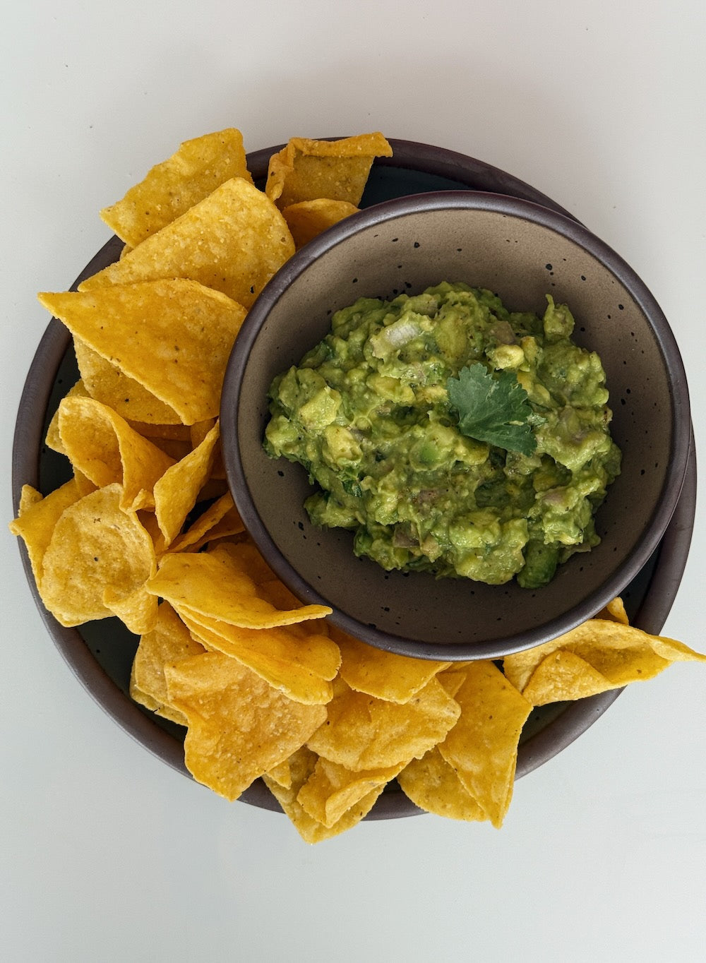 Chips and guacamole on a plate.
