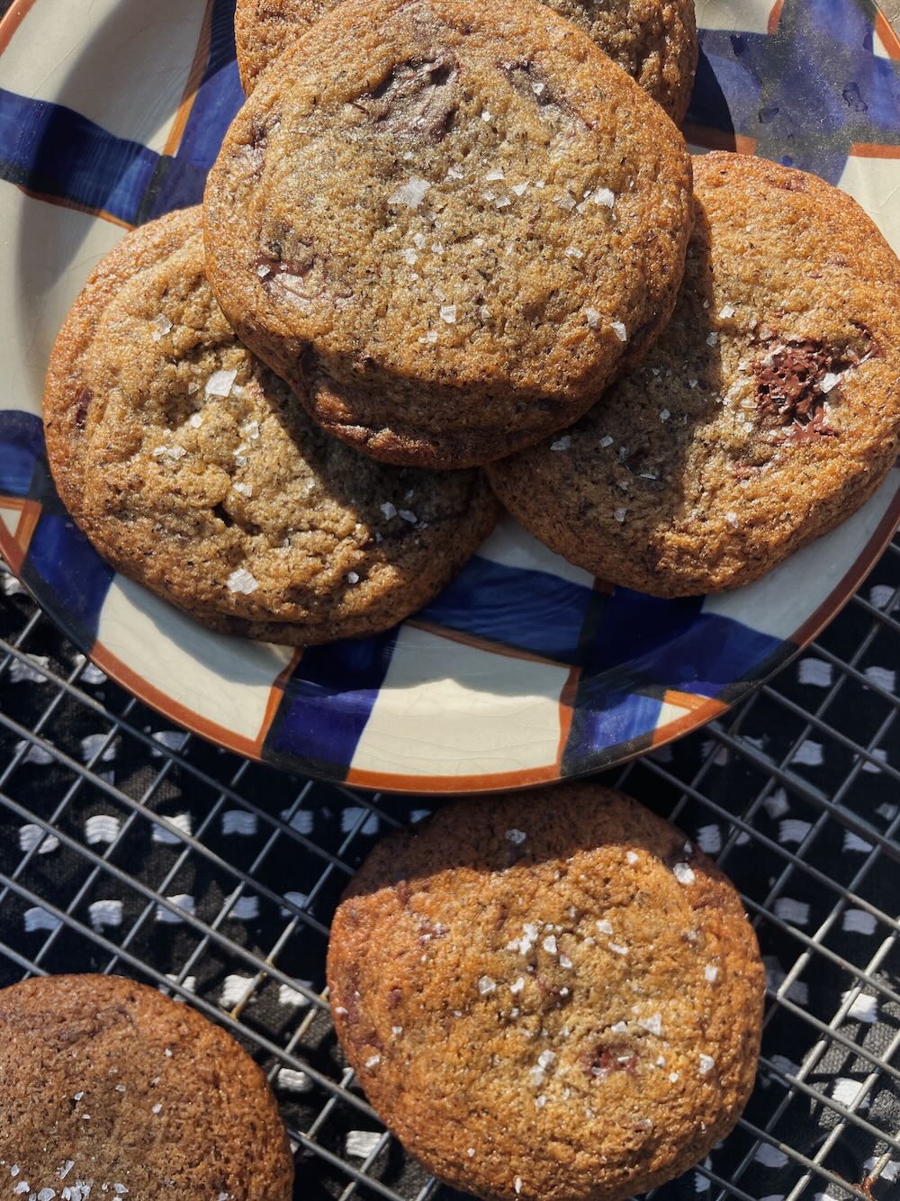 Chocolate chip cookies on plate, with visible flake salt on top.