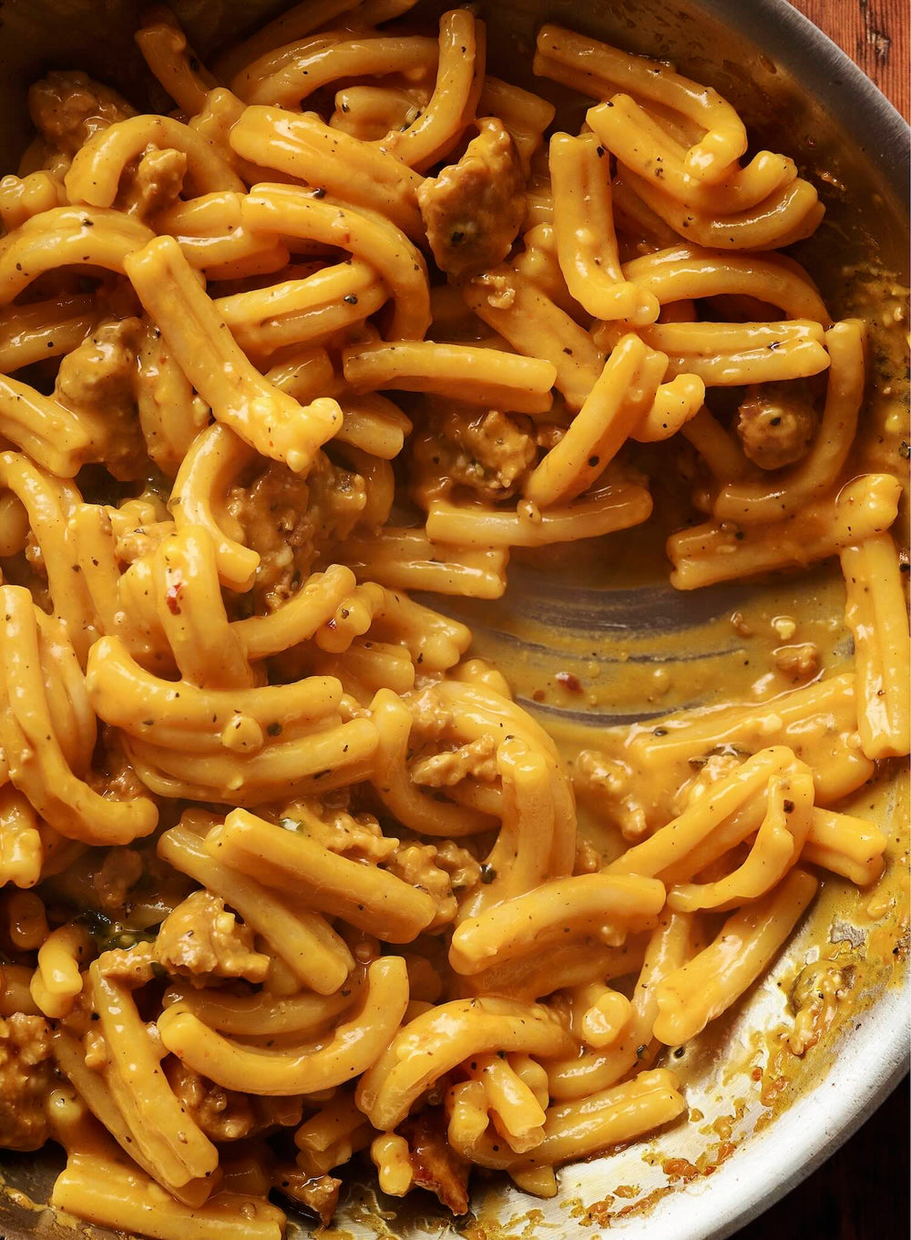 Closeup of yellow pasta on stovetop pan.