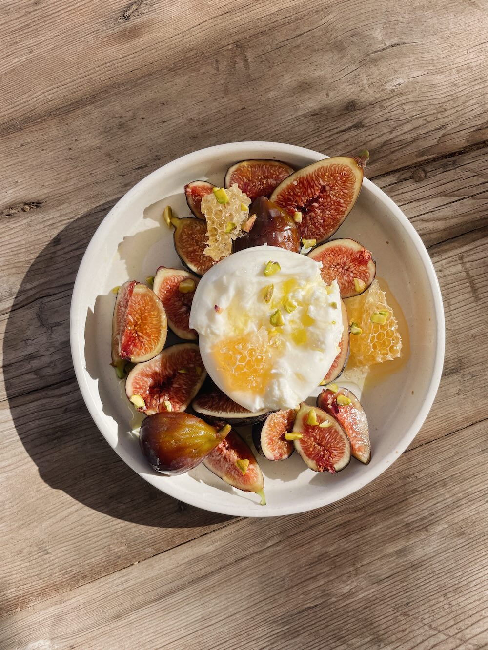 Sliced figs, topped with burrata cheese, olive oil and flake salt.