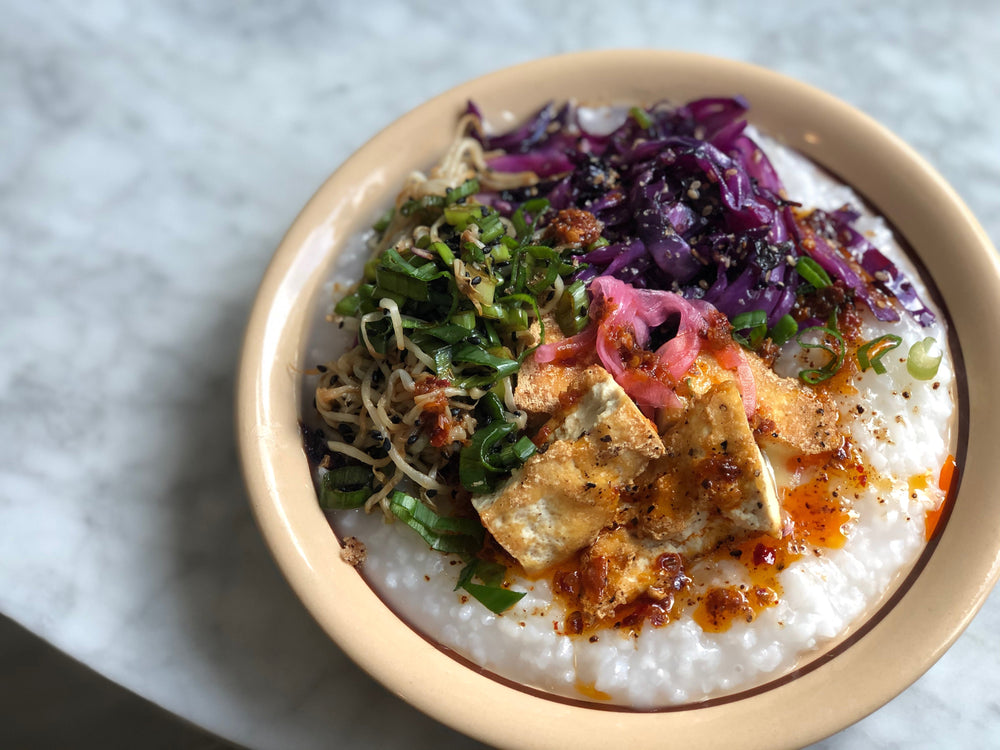 A bowl of savory porridge, called jook, with toppings. 