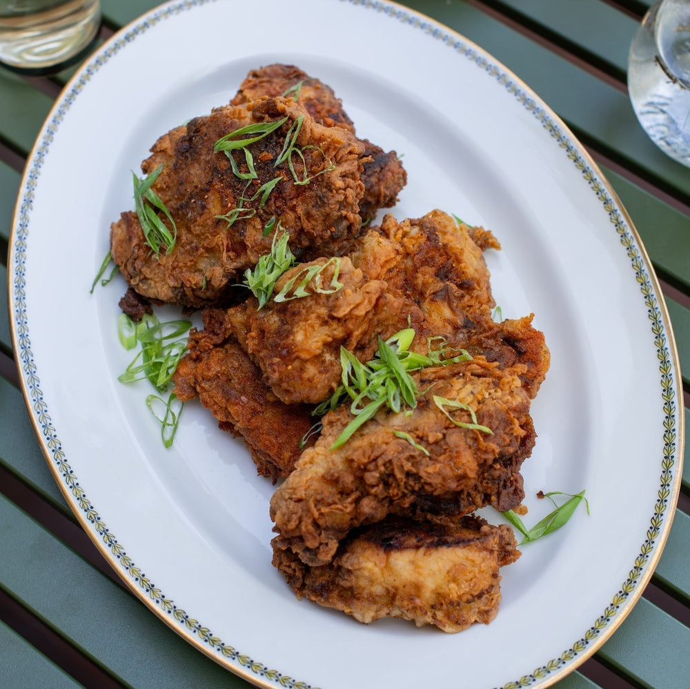 A plate of fried chicken, with diced green onion garnish.