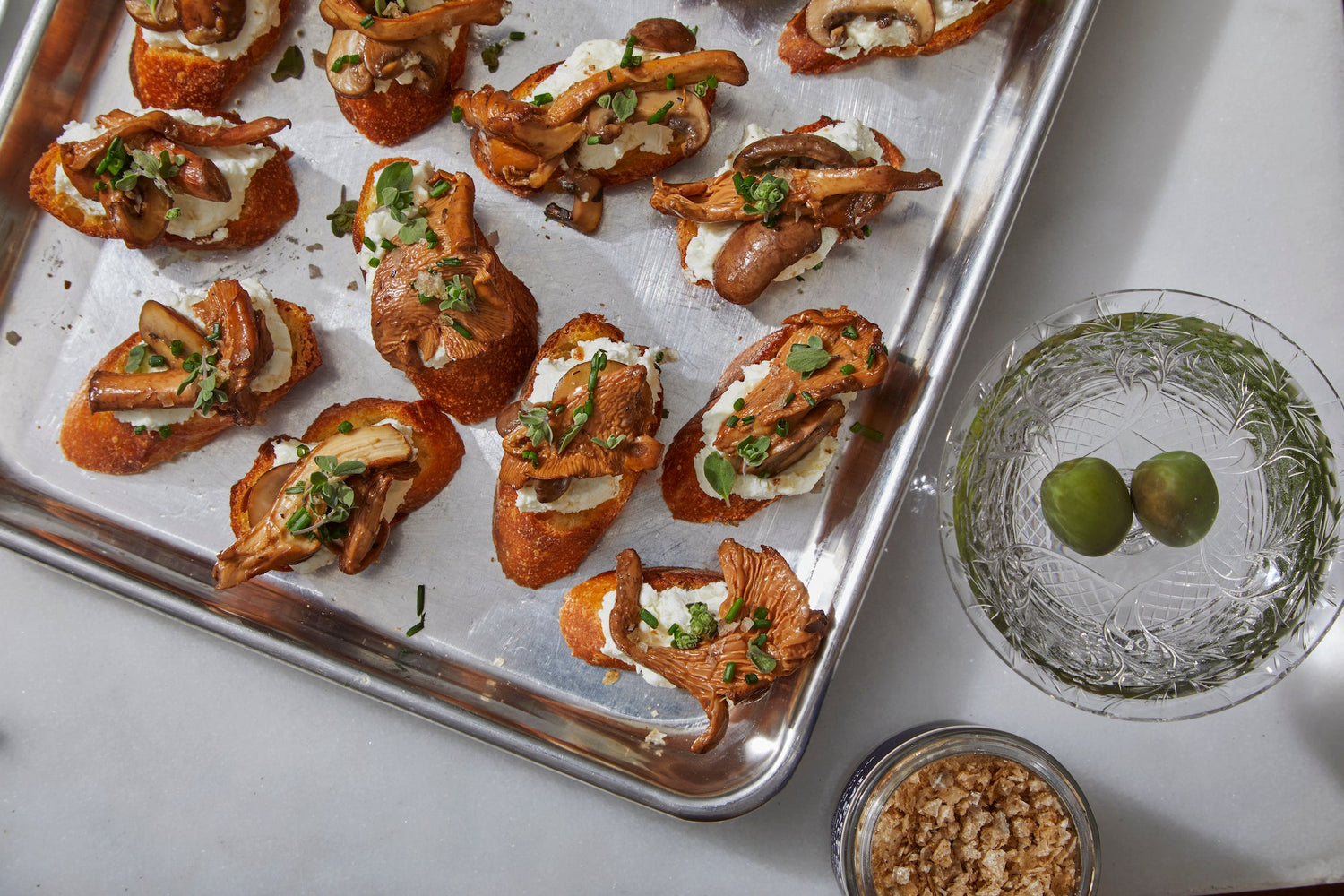 A sheet tray with mushroom, goat cheese, and white truffle salt crostini.