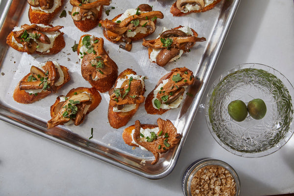 A sheet tray with mushroom, goat cheese, and white truffle salt crostini.