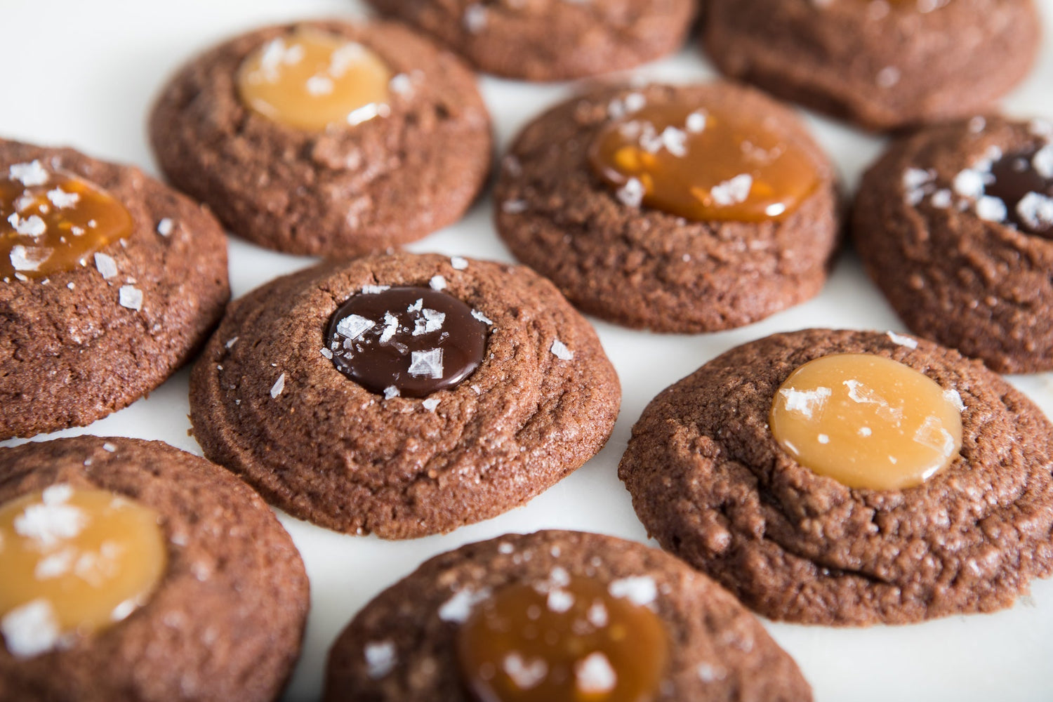 Ten chocolate thumbprint cookies with caramel filling and flakey sea salt.