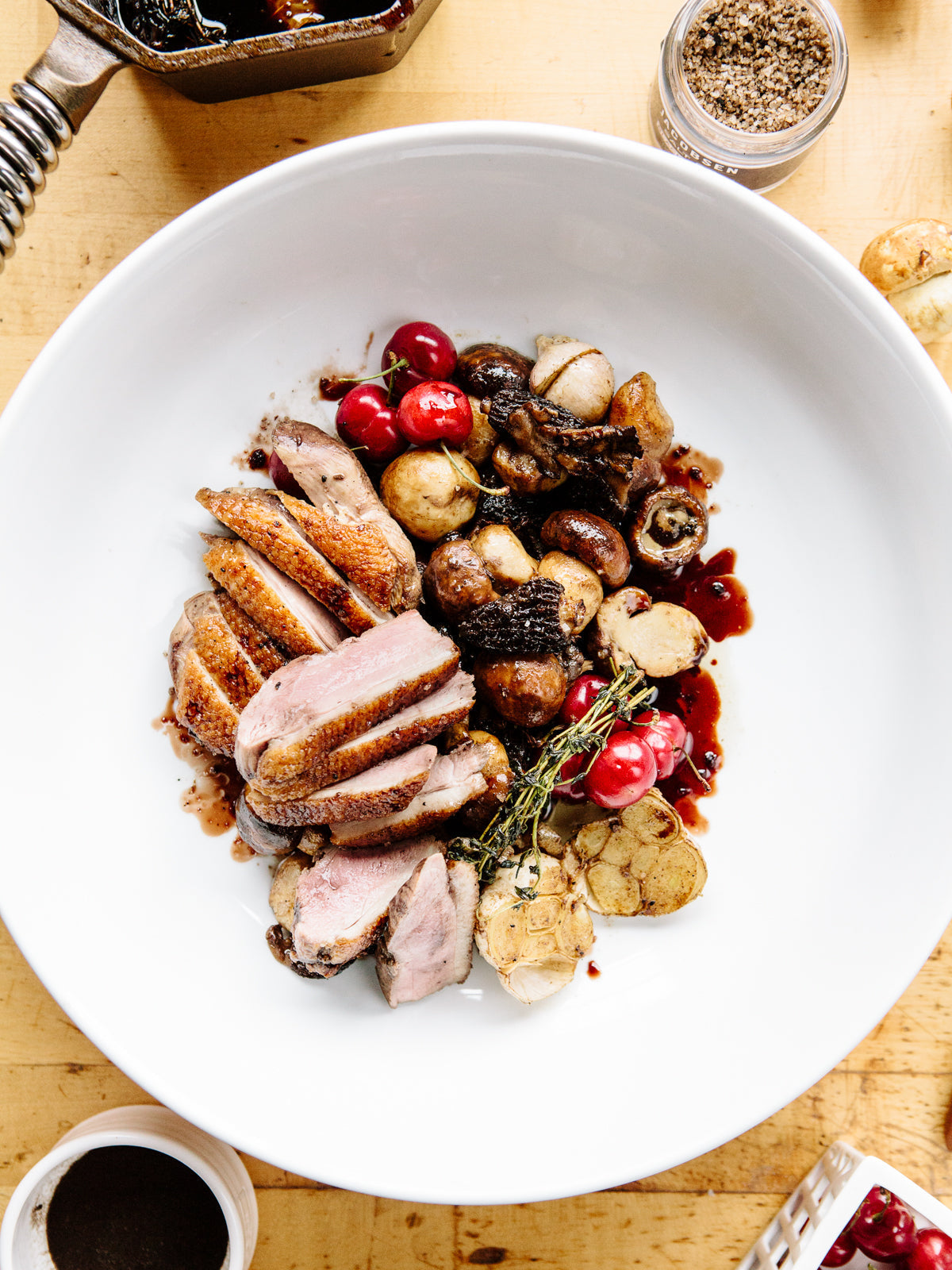 Pan-Roasted duck on a white plate, with tomatoes, mushrooms and potatoes