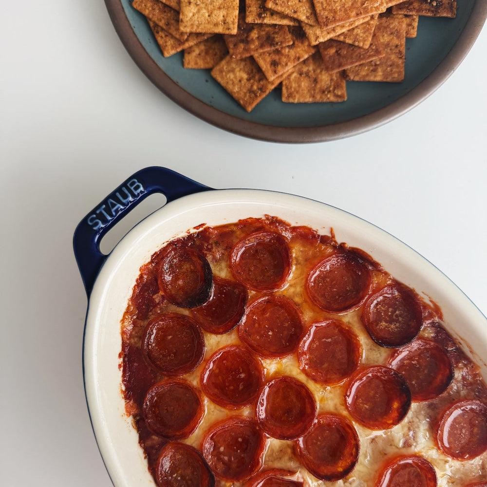 Pizza dip with pepperoni served with seasoned crackers