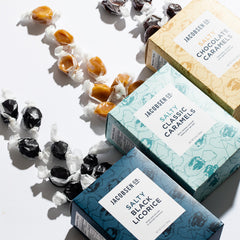Salty Black Licorice, Classic Caramels and Chocolate Caramels with candy spilling out of the boxes onto white countertop.