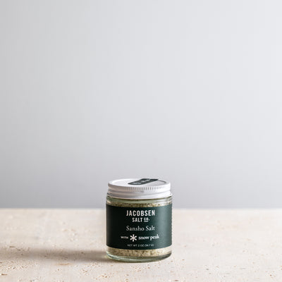 Jar of Jacobsen Salt Co. Sansho Salt on a light surface with a gray background