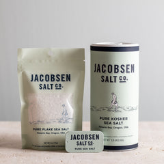Jacobsen Salt Co. bundle of pure Oreogn salt products, including a bag of Pure Flake Sea Salt, a Pure Kosher Sea Salt canister, and a Pure Sea Salt slide tin.