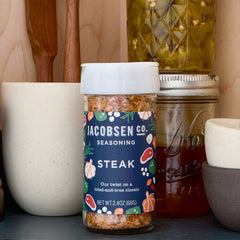 A jar of Jacobsen Steak Seasoning on a pantry shelf.