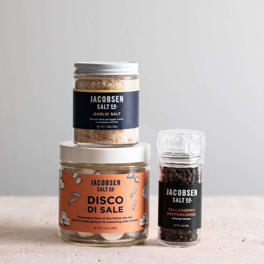 Jacobsen Salt Co bundle, including a jar of Garlic Salt, a jar of Disco di Sale and a grinder of Tellicherry peppercorns.